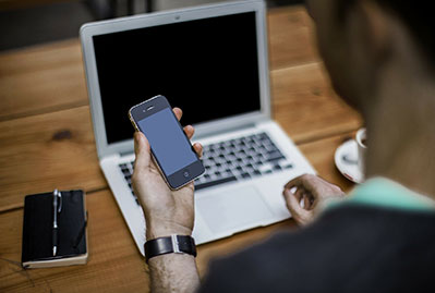 Blogger on his cellphone and computer