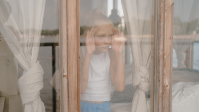 child peeking out window